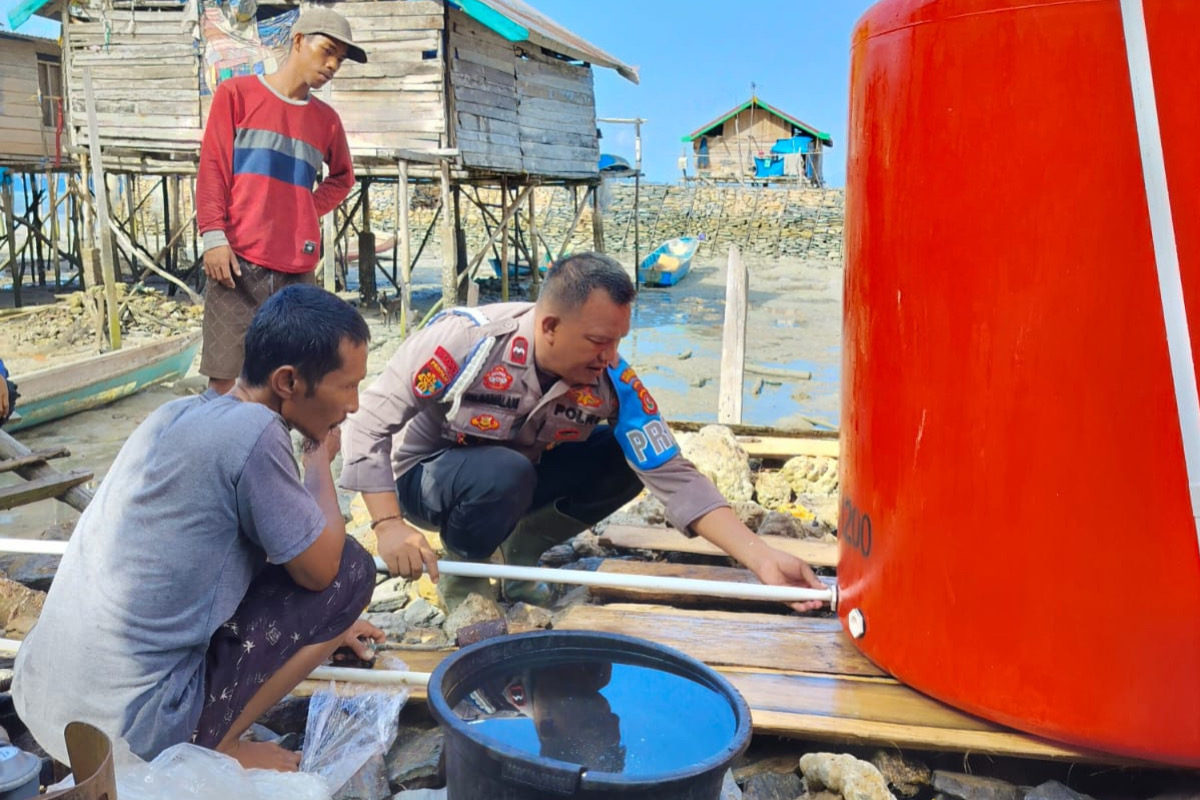 Aiptu Sisran (43), yang bertugas sebagai Ps Kanit Propam Polsek Laonti membantu masyarakat di desa kecil pesisir Konsel. Foto: Istimewa.